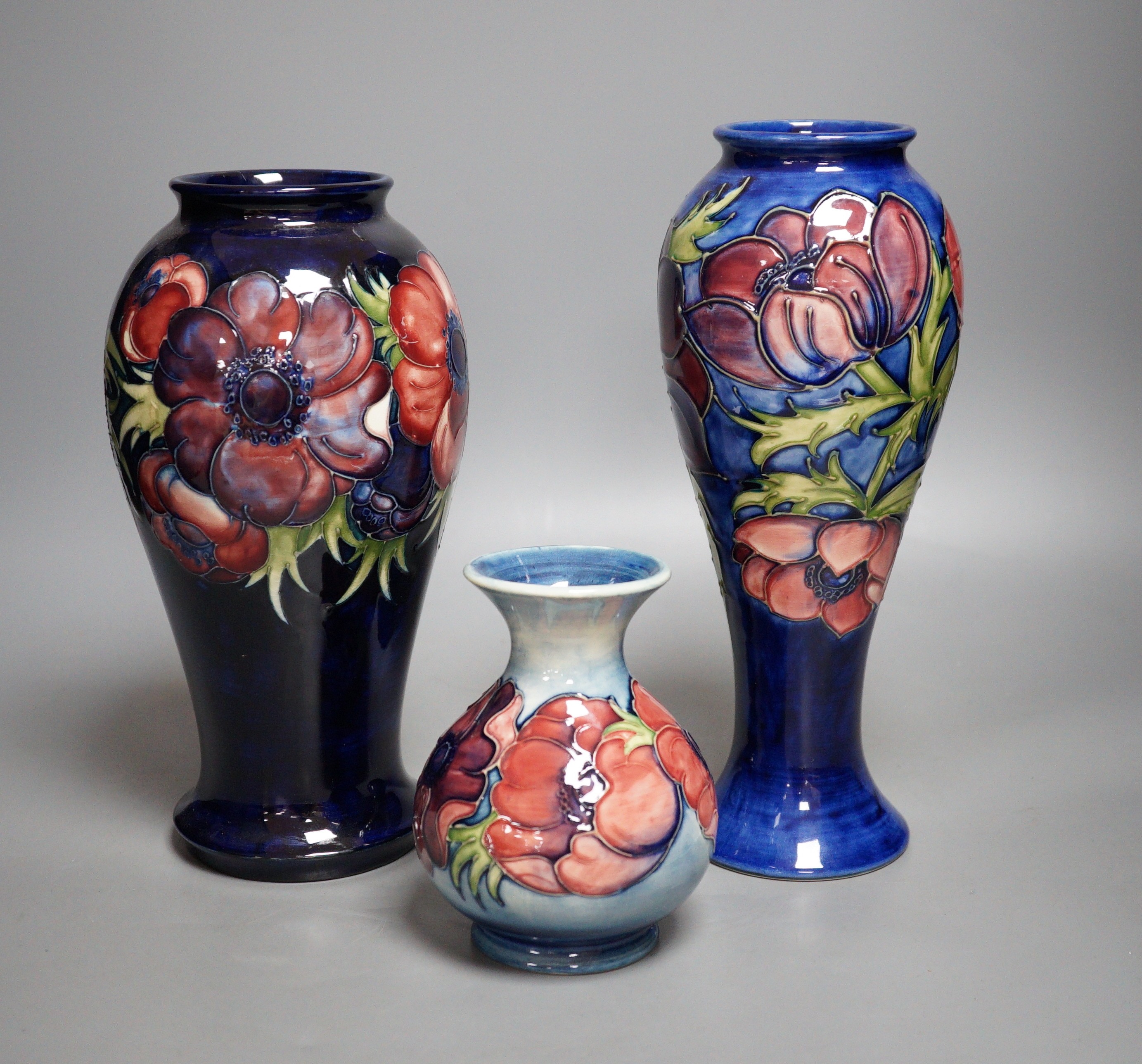 Three William Moorcroft anemone pattern vases, tallest 27cm